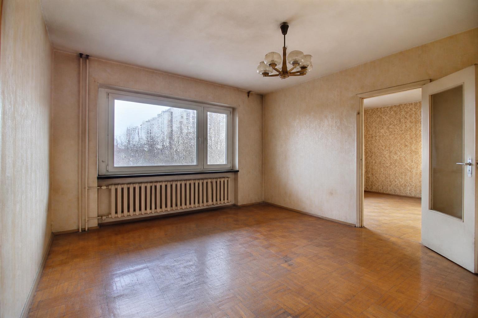 Wohnzimmer vor der Renovierung mit alter Tapete und altem Boden